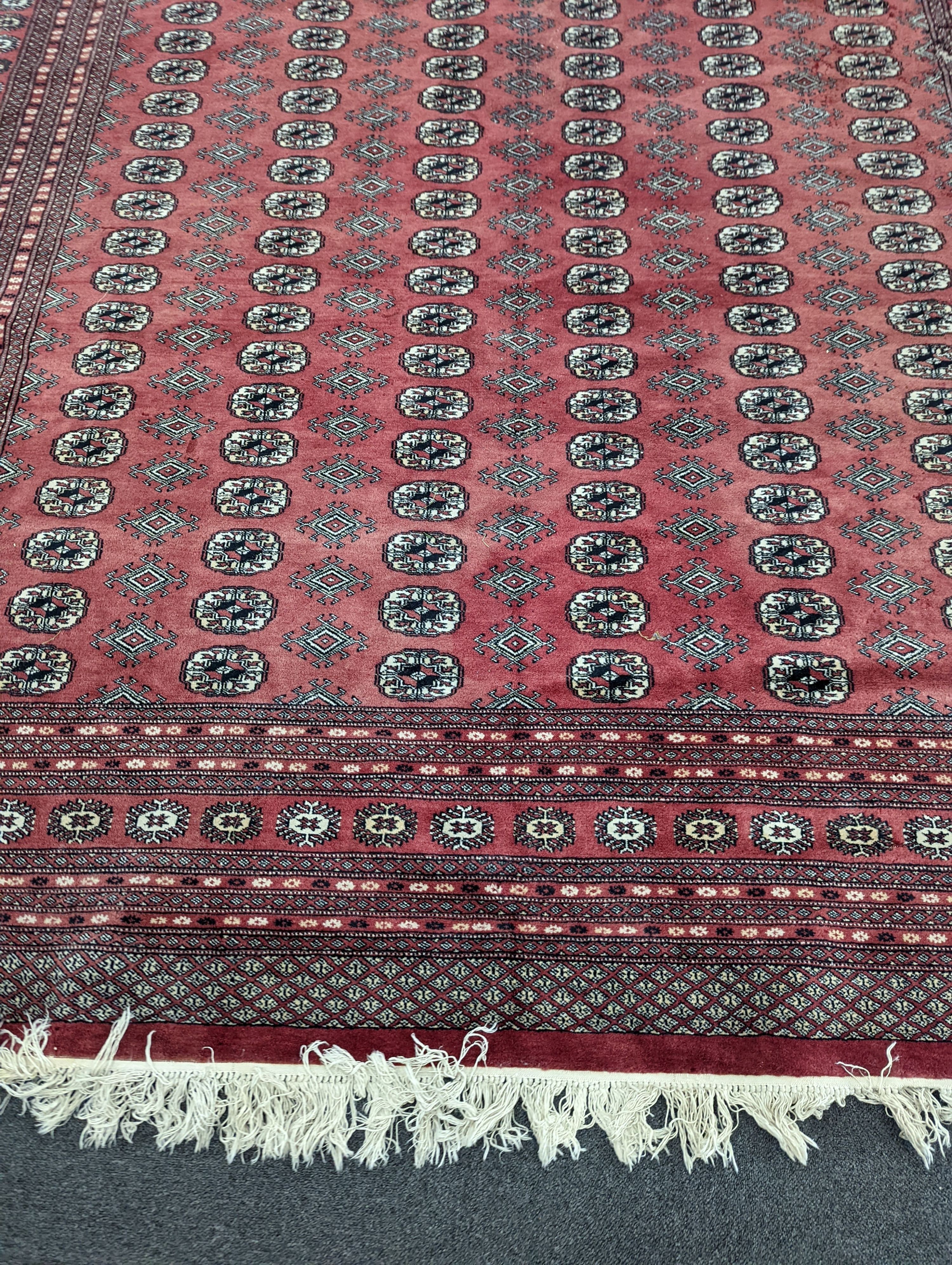 A Bokhara burgundy ground carpet, 360 x 276cm